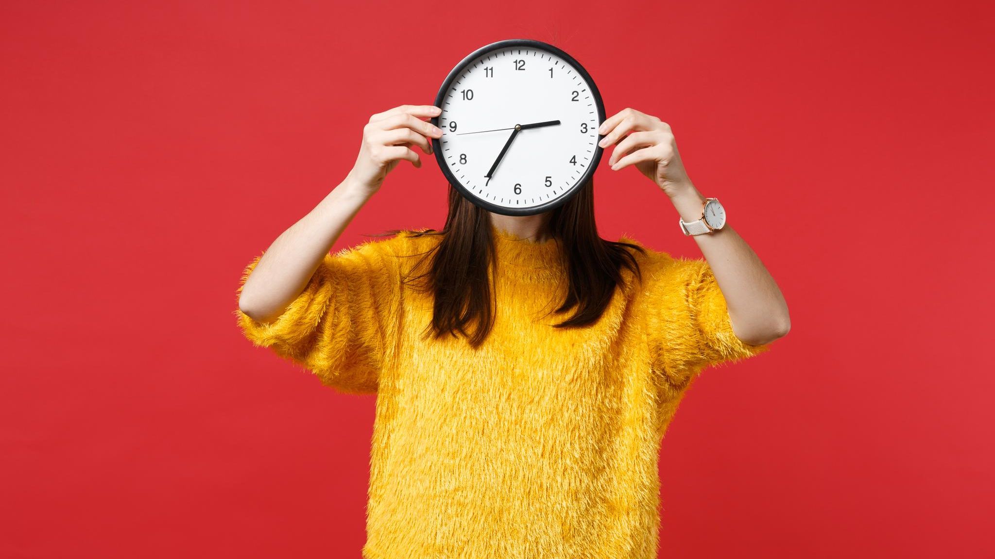 Teilzeit: Frau hält Uhr hoch