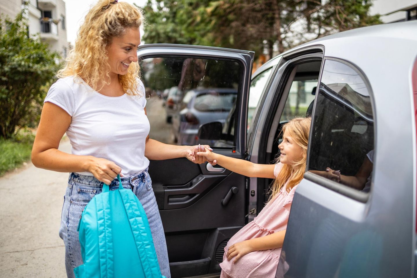 Mutter hilft Kind aus dem Auto