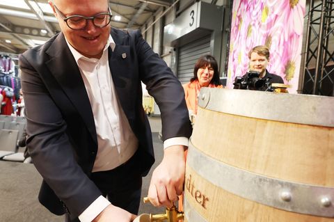 Thüringens Ministerpräsident Mario Voigt schlug bei der "Thüringen-Ausstellung" ein Bierfass an. Foto: Bodo Schackow/dpa