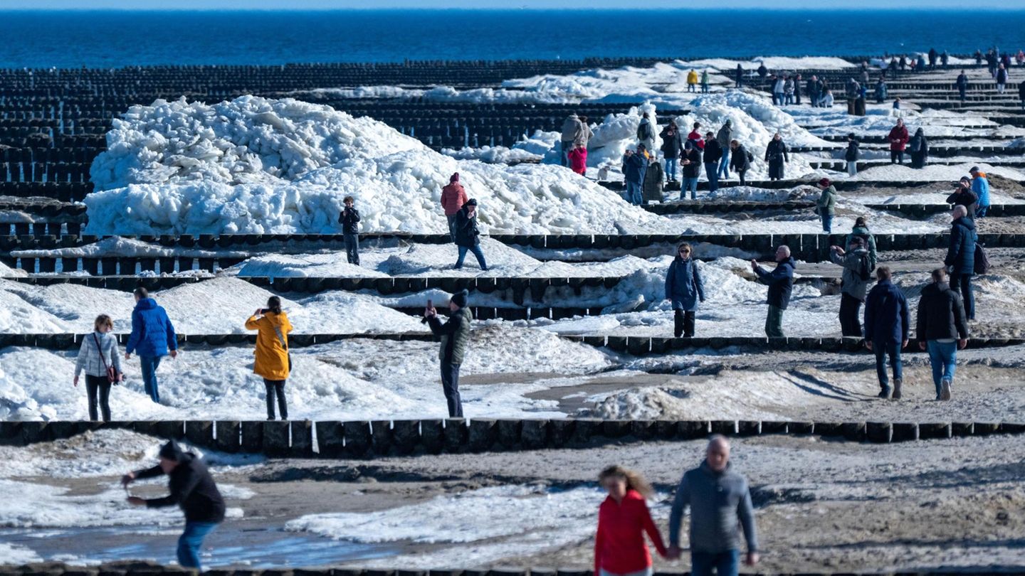 Zempin, Mecklenburg-Vorpommern. Touristen und Einwohner spazieren am Strand von Zempin. Dort türmen sich auch am meteorologischen Frühlingsanfang noch Eisschollen zu mehreren Metern Höhe.