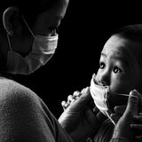 Während der Covid-Pandemie verschwand das Lächeln hinter Masken. Verdeckte Gesichter überall: in der Bahn, im Supermarkt, auf offener Straße. Wie vermittelt man den Kleinsten, dass eine unsichtbare Gefahr droht? Und dass ein dünnes Vlies vor Mund und Nase davor schützen kann? Mit Liebe. Das Bild von Pyae Phyo Htike zeigt eine Mutter in Myanmar, die ihrem Sohn sanft eine Maske aufsetzt. Der Junge schaut sie fragend an, ihr Blick antwortet: Hier geschehen schwer verständliche Dinge. Aber ich bin bei dir und passe auf dich auf.