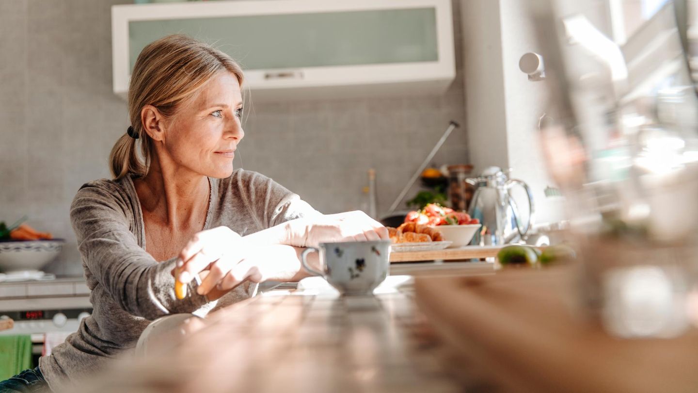 Ehe: Eine Frau sitzt an einem Tisch in einer Küche