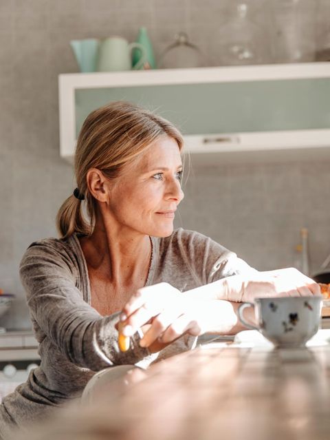 Ehe: Eine Frau sitzt an einem Tisch in einer Küche