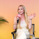 Lindsay Lohan winkt, während sie in ein Mikrofon spricht