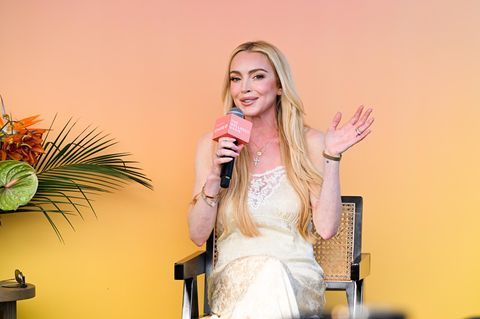 Lindsay Lohan winkt, während sie in ein Mikrofon spricht