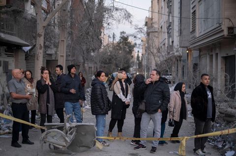 Menschen in einem von US-Bomben zerstörten Teil der iranischen Hauptstadt Teheran