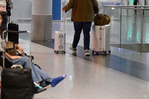 Ein Reisender schiebt seine Koffer im Abflug-Terminal des Flughafens Düsseldorf. (Symbolbild) Foto: Roberto Pfeil/dpa