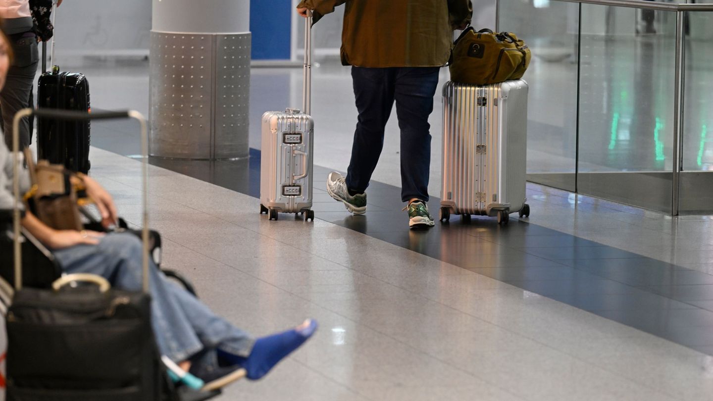 Ein Reisender schiebt seine Koffer im Abflug-Terminal des Flughafens Düsseldorf. (Symbolbild) Foto: Roberto Pfeil/dpa