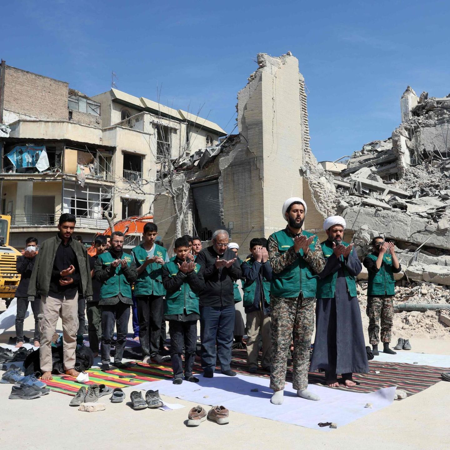 Teheran, Iran. Kleriker und Angehörige der Basidsch-Miliz beten neben einer zerbombten Polizeistation. Sie helfen dabei, den Schutt zu beseitigen. Die Basidsch-Miliz gehört zu den Revolutionsgarden und ist eines der brutalsten Unterdrückungsinstrumente des Regimes. Ihre Mitglieder überwachen, prügeln, morden und werden grundsätzlich für die Drecksarbeit der Terror-Mullahs eingesetzt.