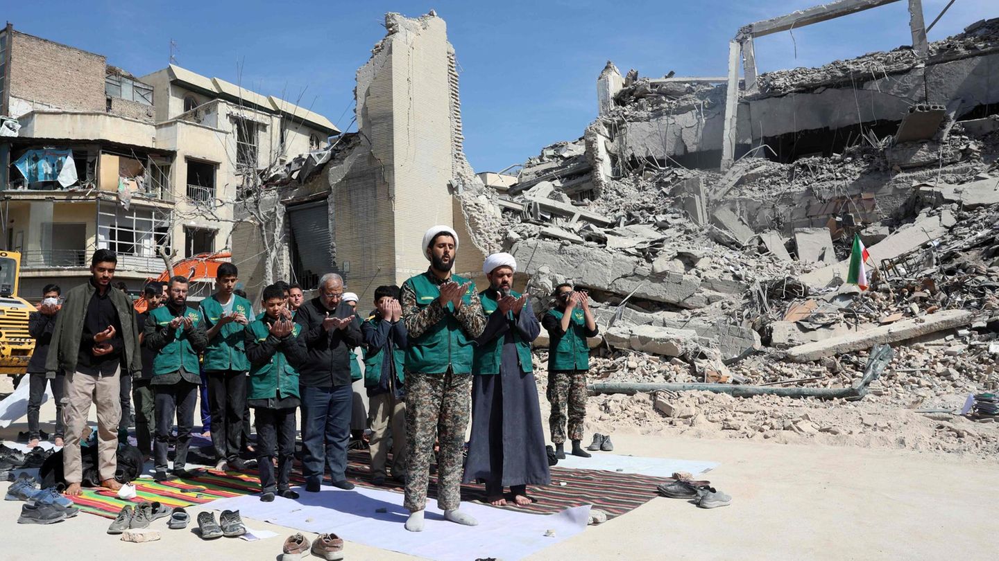 Teheran, Iran. Kleriker und Angehörige der Basidsch-Miliz beten neben einer zerbombten Polizeistation. Sie helfen dabei, den Schutt zu beseitigen. Die Basidsch-Miliz gehört zu den Revolutionsgarden und ist eines der brutalsten Unterdrückungsinstrumente des Regimes. Ihre Mitglieder überwachen, prügeln, morden und werden grundsätzlich für die Drecksarbeit der Terror-Mullahs eingesetzt.