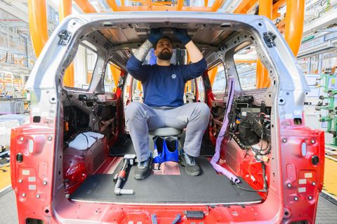 Ein Mitarbeiter montiert einen Elektro-Bulli ID. Buzz im Werk von Volkswagen Nutzfahrzeuge. Foto: Julian Stratenschulte/dpa