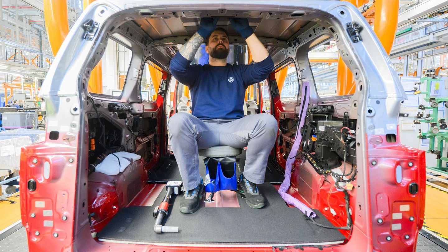 Ein Mitarbeiter montiert einen Elektro-Bulli ID. Buzz im Werk von Volkswagen Nutzfahrzeuge. Foto: Julian Stratenschulte/dpa