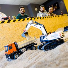 Gründer Siymo Othman (links) steuert mit Freunden kleine Bagger, Radlader und Lastwagen in seinem neu eröffneten Bagger-Café. Es