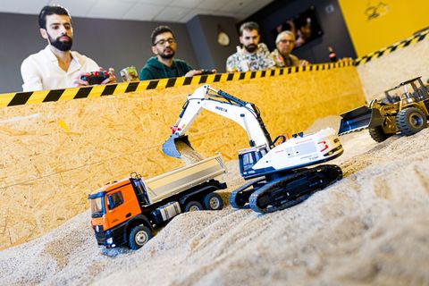 Gründer Siymo Othman (links) steuert mit Freunden kleine Bagger, Radlader und Lastwagen in seinem neu eröffneten Bagger-Café. Es