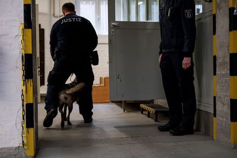 Ein Hund der justizeigenen Hundestaffel läuft mit einem Justizbeamten in der Justizvollzugsanstalt Tegel. (Archivbild) Foto: Fab