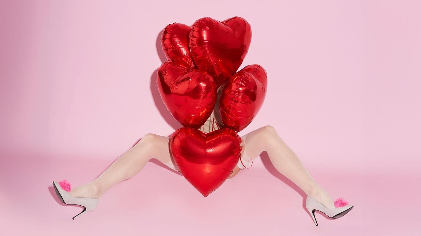 Eine Frau mit gespreizten Beinen und Herz-Ballons