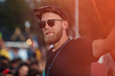 Ein Mann steht ohne Freunde bei einem Festival