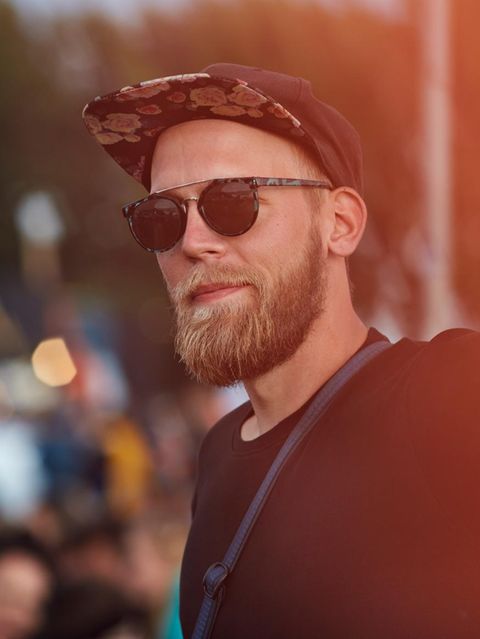 Ein Mann steht ohne Freunde bei einem Festival