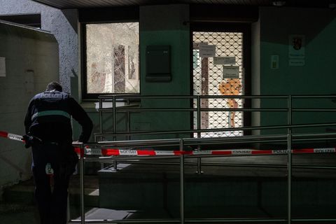 Ein Polizist befestigt ein Absperrband vor der Polizeiinspektion Bitburg