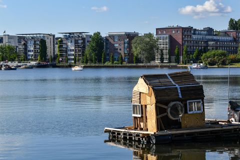 Ein Floß mit einem zusammengezimmerten Holzhaus schwimmt auf dem Rummelsburger See. (Archivbild) Foto: Jens Kalaene/dpa-Zentralb