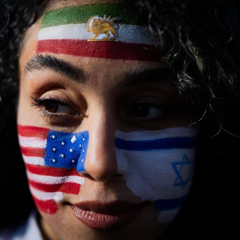 Berlin, Deutschland. Mozhgan nimmt mit den auf das Gesicht gemalten Flaggen der USA, Israels und des Irans an einem Protest unter dem Motto „Feiern des getöteten Diktators des Iran“ am Brandenburger Tor teil. Hunderte Menschen haben bei der Kundgebung am Brandenburger Tor Freiheit für den Iran gefordert. Redner erinnerten an die Tausenden Menschen, die während der Proteste zu Beginn des Jahres im Iran ermordet wurden, und an die Tausenden, die noch gefangen gehalten werden. Viele Teilnehmer der Kundgebung schwenkten iranische Fahnen. Vor der Bühne hingen auch eine deutsche, eine israelische und eine amerikanische Flagge.