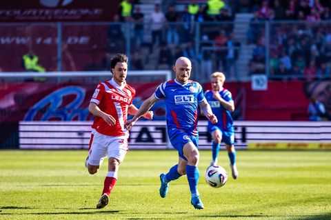 Simon Straudi (FC Energie Cottbus, l) unnd Maximilian Krauß (Hansa Rostock) kämpfen um den Ball. Foto: Frank Hammerschmidt/dpa