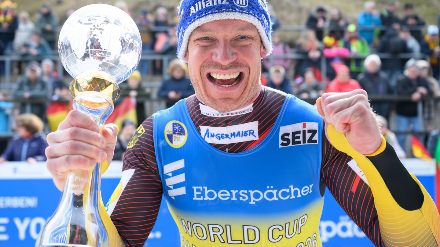 Felix Loch jubelt mit der Kristallkugel für den Gesamtweltcupsieg. Foto: Robert Michael/dpa