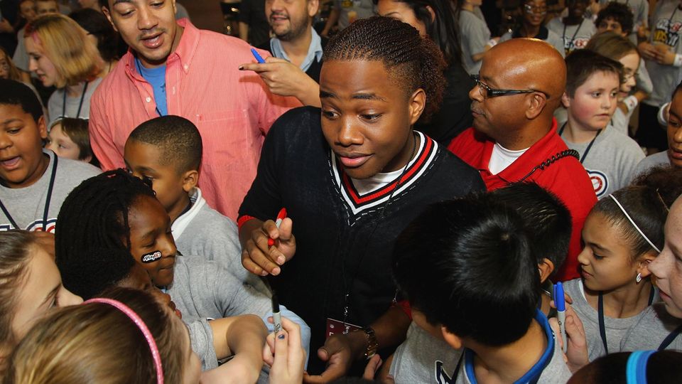 Leon Thomas ist von Kindern umringt und gibt ihnen Autogramme