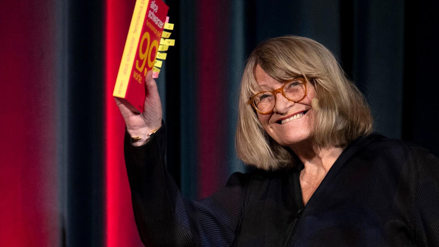 Alice Schwarzer hält ihr Buch in der Hand