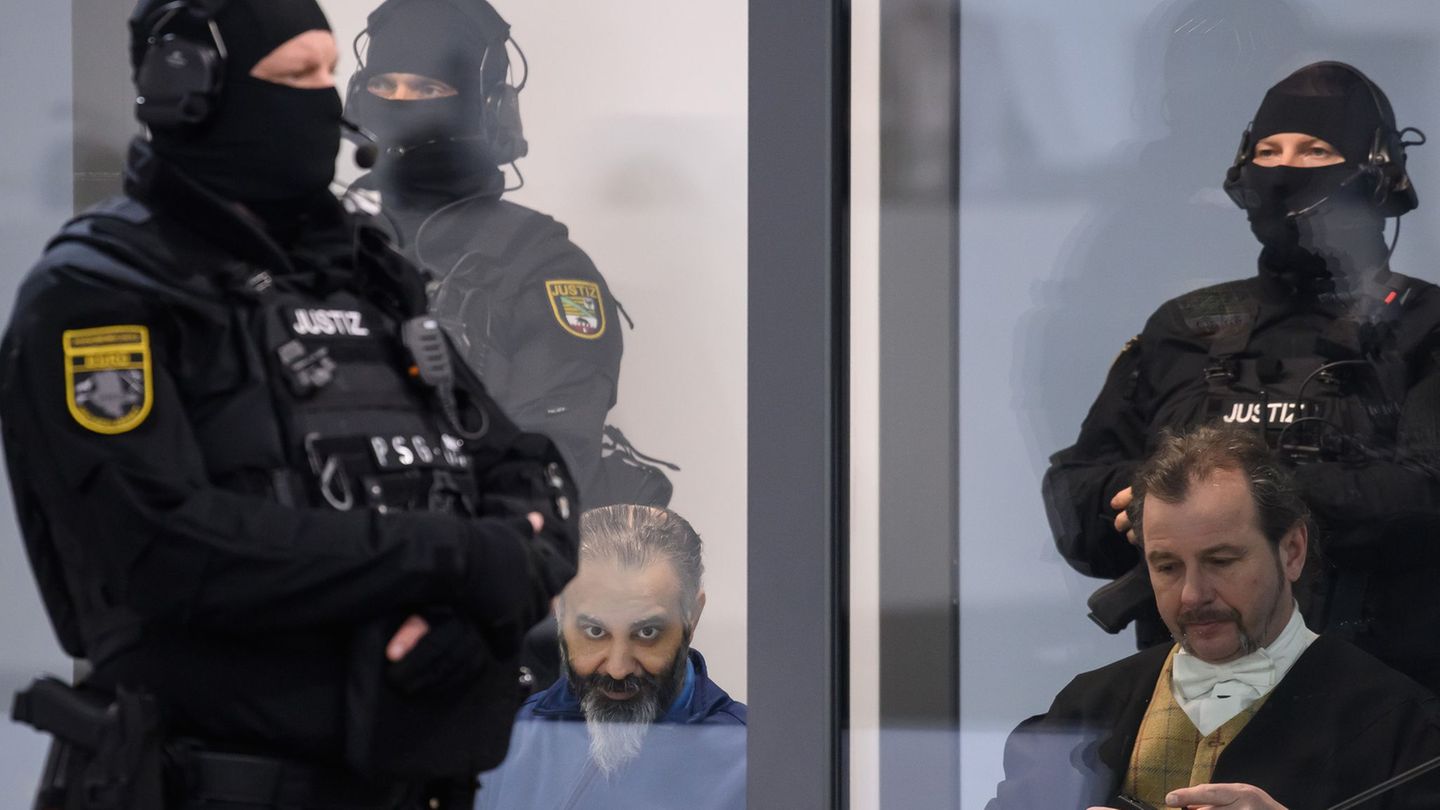 Der Todesfahrer vom Magdeburger Weihnachtsmarkt (l) sitzt während der Verhandlung hinter Glas und wird von Spezialkräften der Ju