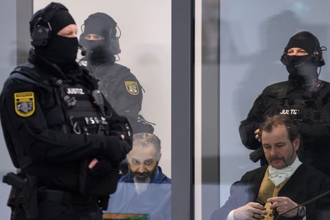 Der Todesfahrer vom Magdeburger Weihnachtsmarkt (l) sitzt während der Verhandlung hinter Glas und wird von Spezialkräften der Ju