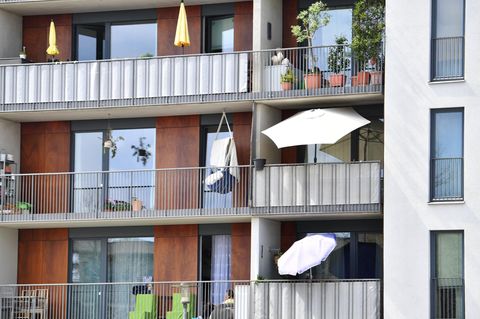Aufgespannte Sonnenschirme auf Balkonen in Wohnungen