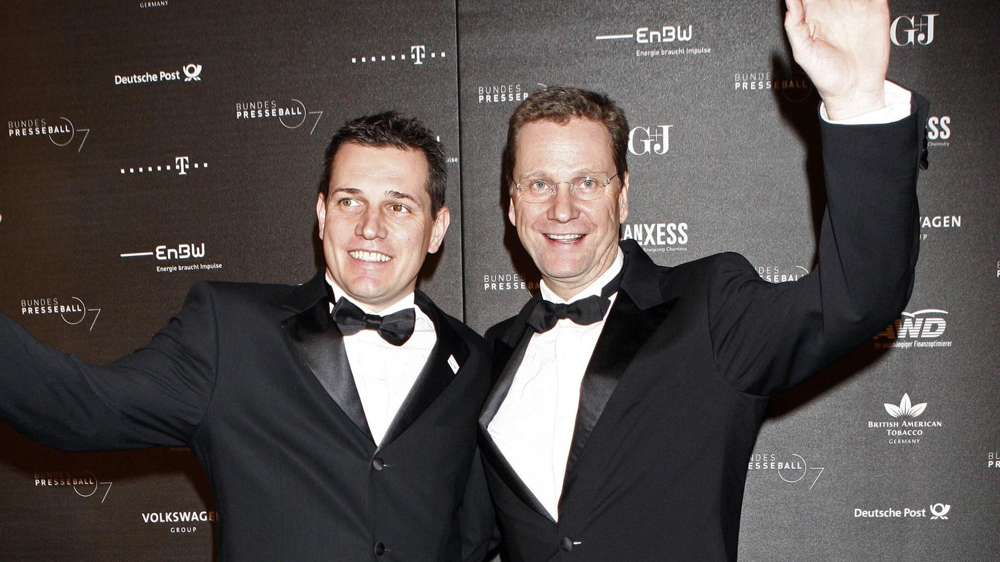 Guido Westerwelle und Michael Mronz winken auf dem roten Teppich