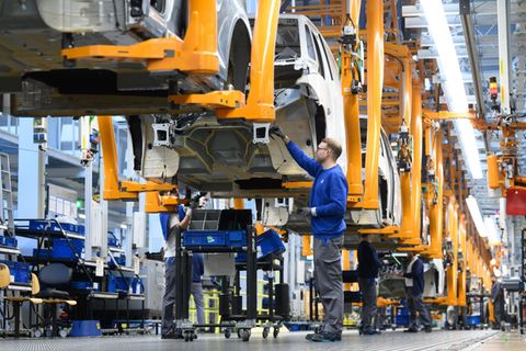 Mitarbeiter montieren Elektro-Bullis ID Buzz im Werk von VW-Nutzfahrzeuge