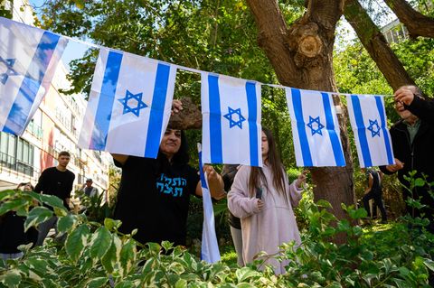 Menschen sitzen versammelt auf einem Platz in Israel