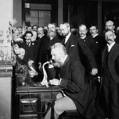 Graham Bell am Telefon inmitten einer Menschenmenge