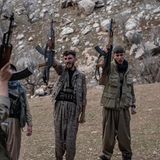 Iranische Dissidentengruppe hält Gewehre in die Luft, die andere Hand zur Faust geballt rufen sie etwas gemeinsam.