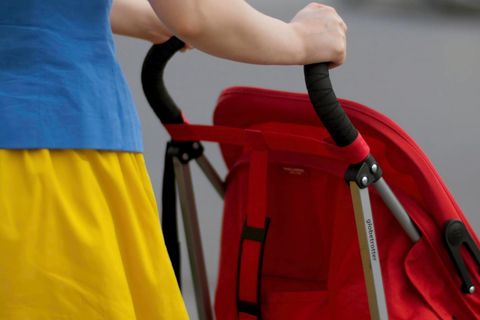 Eine Frau schiebt einen Kinderwagen