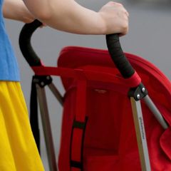 Eine Frau schiebt einen Kinderwagen