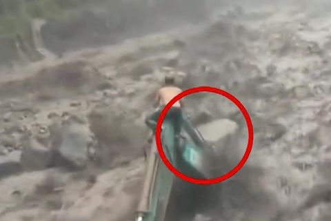 Mann klammert sich verzweifelt an Bagger