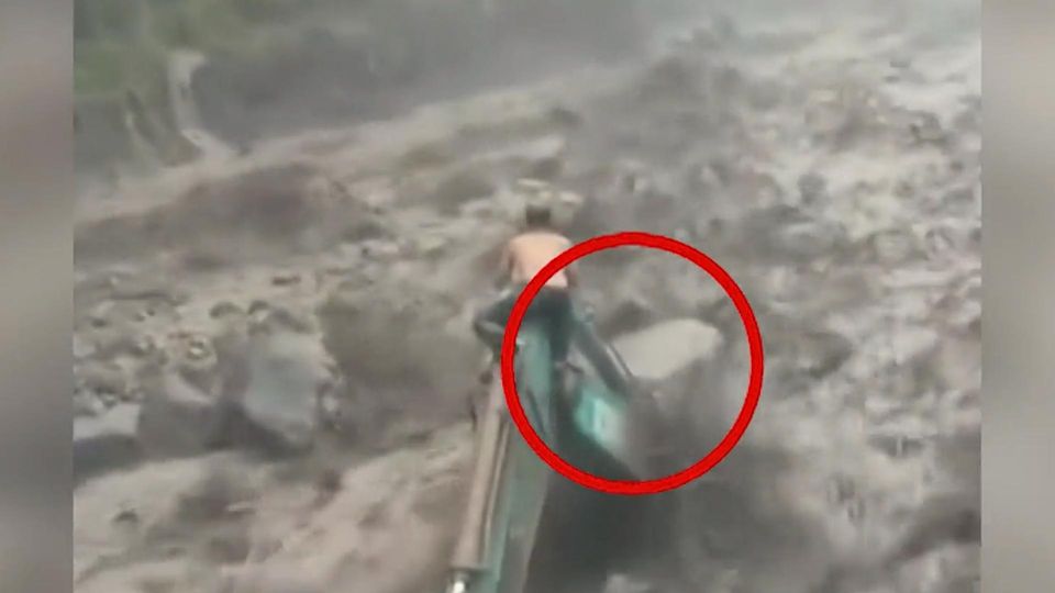 Mann klammert sich verzweifelt an Bagger