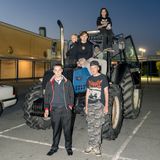 Sechs junge Teenager posieren auf einem Traktor in der Abenddämmerung