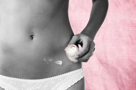 Testosteron: Ein weiblicher Bauch mit Creme in der Nähe des Bauchnabel