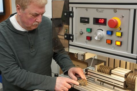 Mit einer Präzisionssäge schneidet Stephan Decker hauchdünne Scheiben von den Steinen ab. Foto: Thomas Frey/dpa