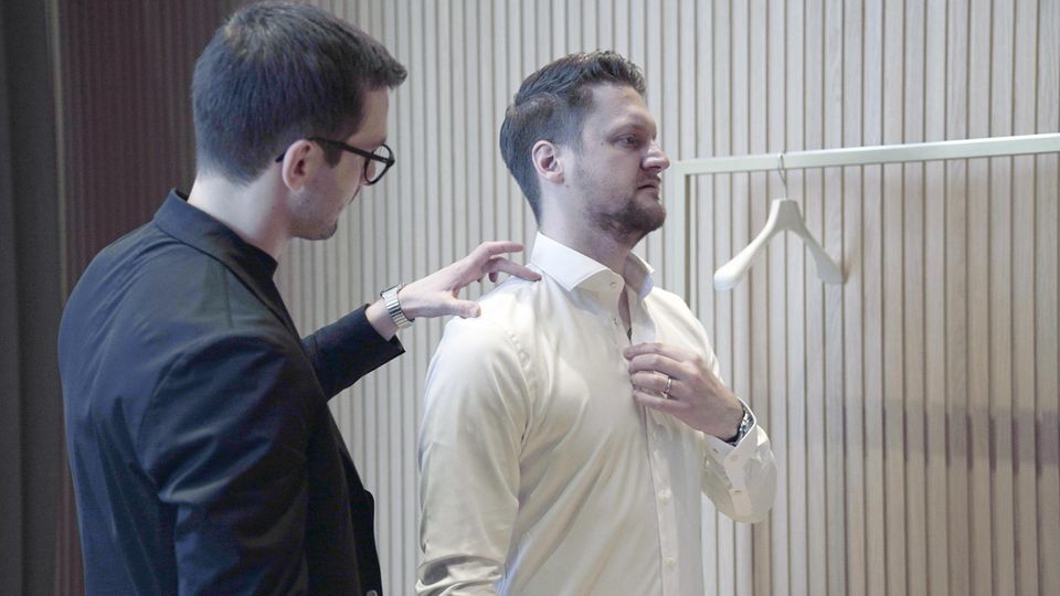 Der Tester und ein Breuninger-Mitarbeiter prüfen die Passform der Hemden