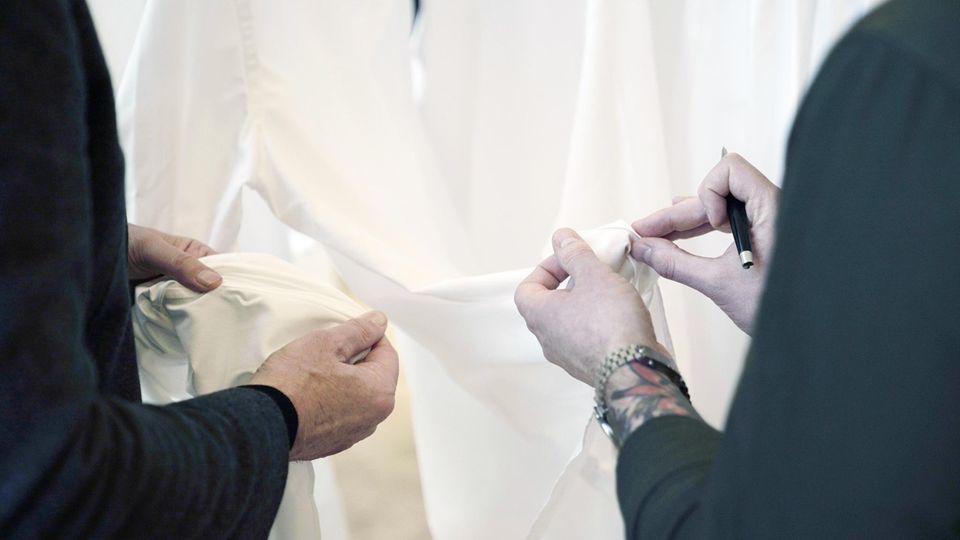 Breuninger-Mitarbeiter prüfen händisch die Nähte der Hemden