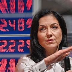 Reiche vor einer digitalen Tafel mit Spripreisen