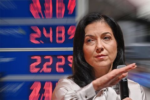 Reiche vor einer digitalen Tafel mit Spripreisen