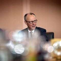 Friedrich Merz während er redet, in einem blauen Anzug  - er schaut mit zusammengezogenen Augenbraun leicht nach oben
