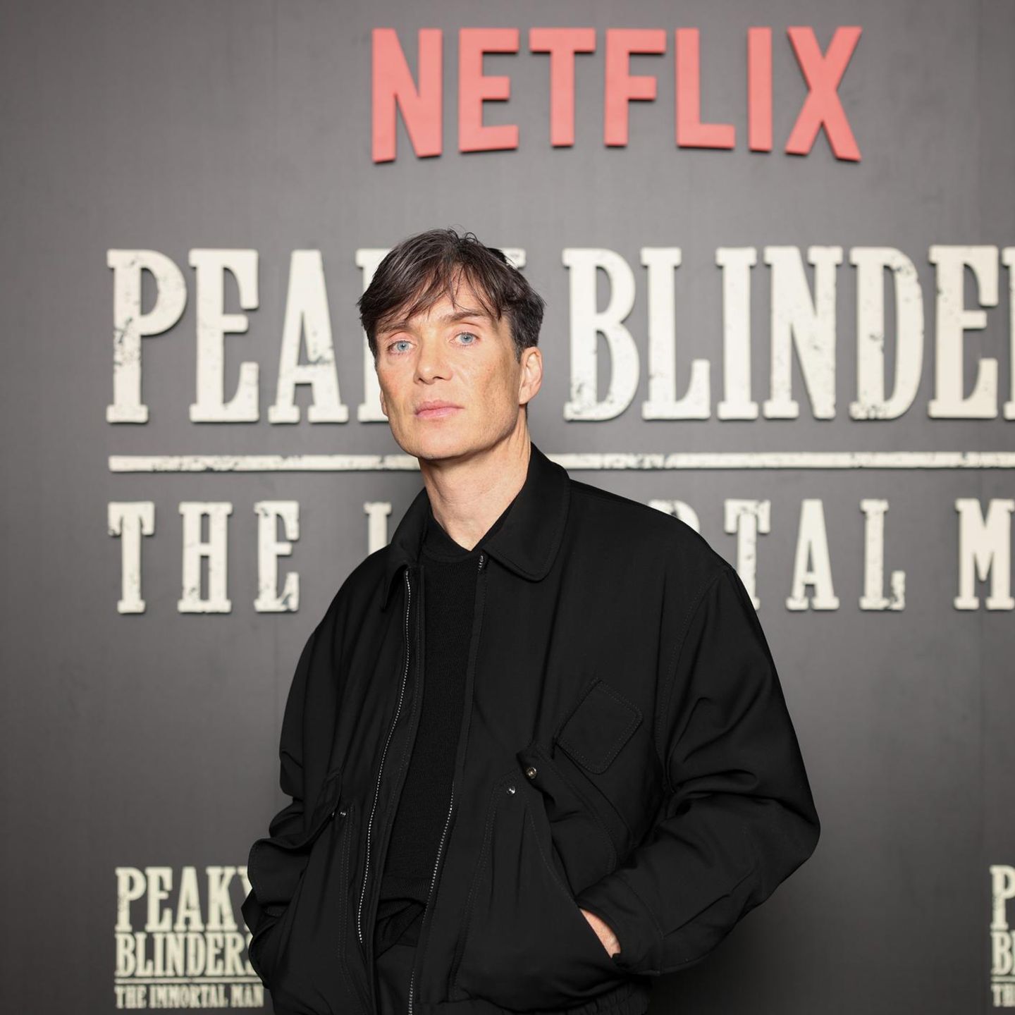 Cillian Murphy vor einem Plakat des „Peaky Blinders“-Film